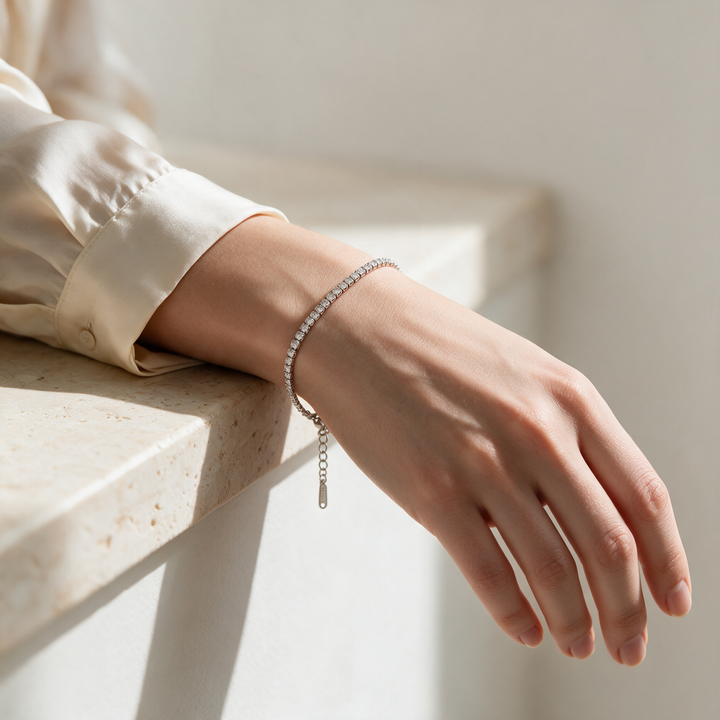 Silver bracelet worn on wrist, soft studio daylight on stone ledge