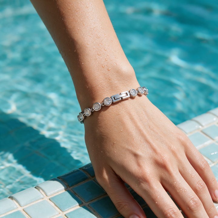 Silver bracelet on wrist at pool edge, midday sun