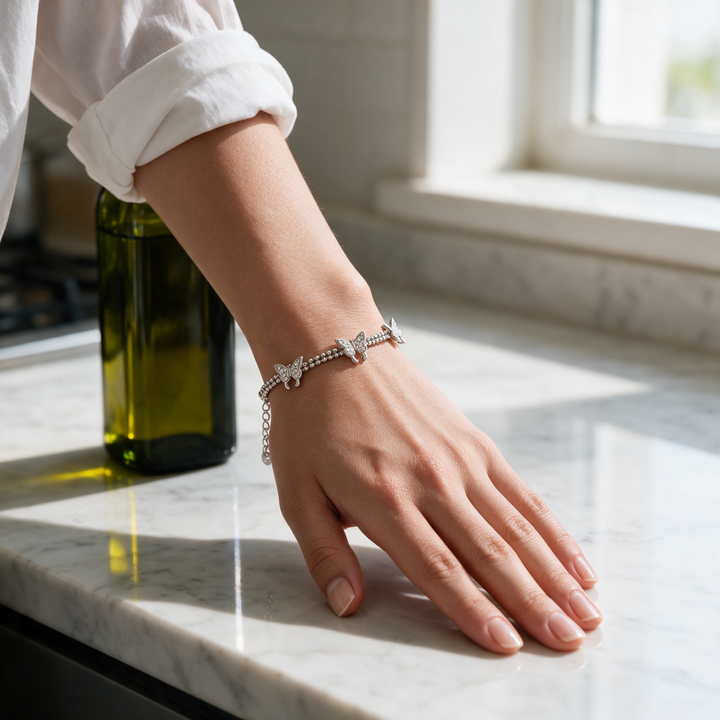 Silver bracelet on hand on marble kitchen counter