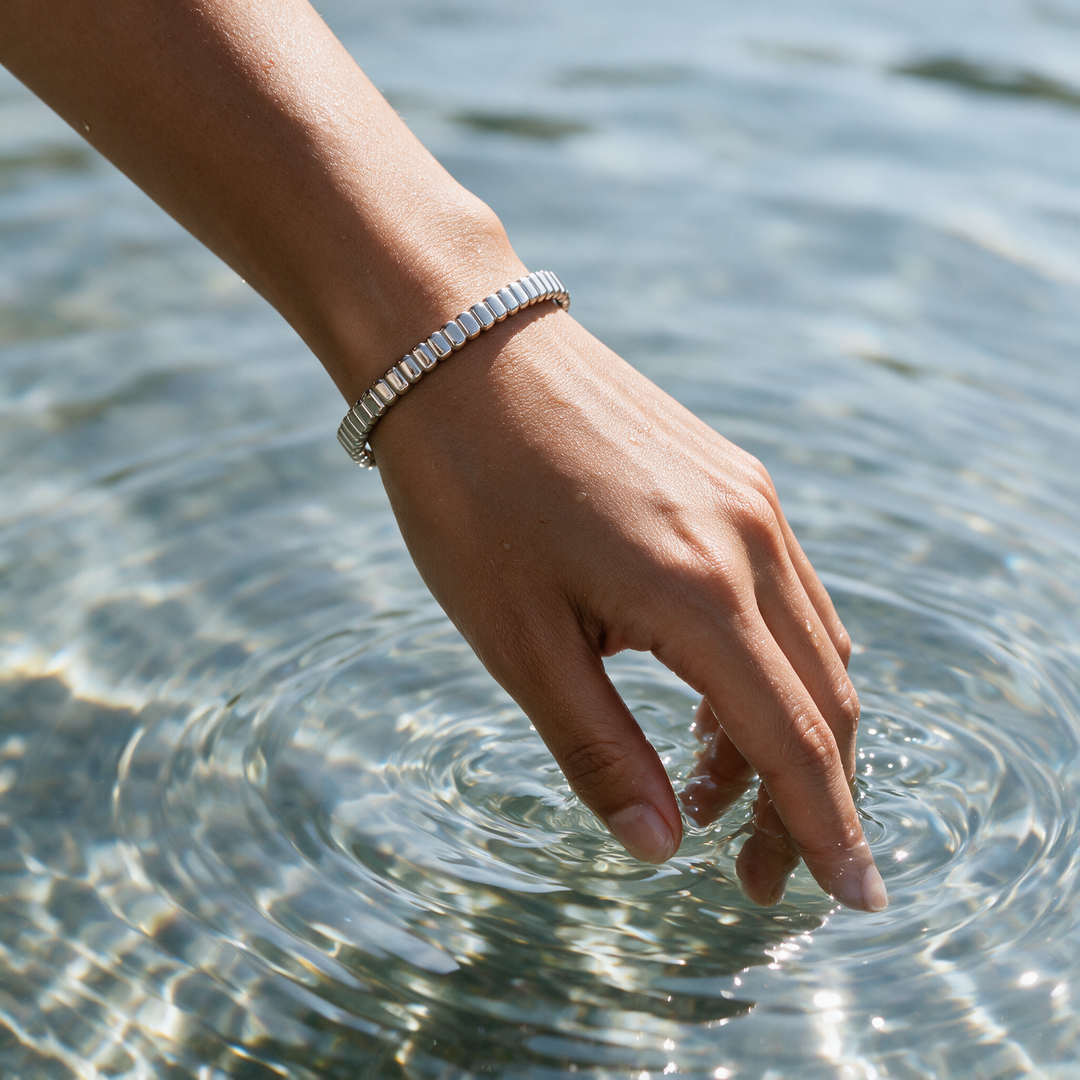 Silver bracelet on hand dipping fingertips into water