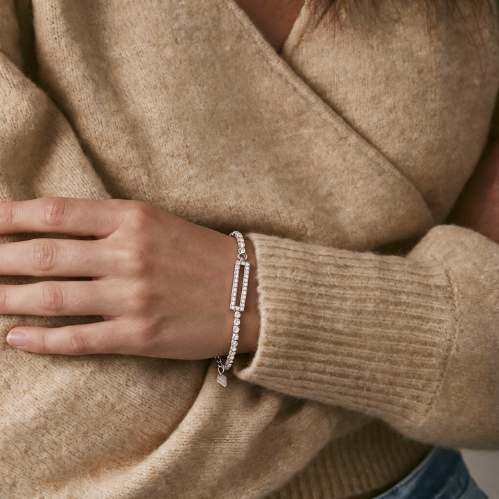 Silver bracelet worn on wrist, camel knit sweater