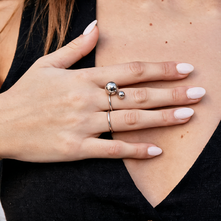 Silver open ring with double ball terminals worn on hand