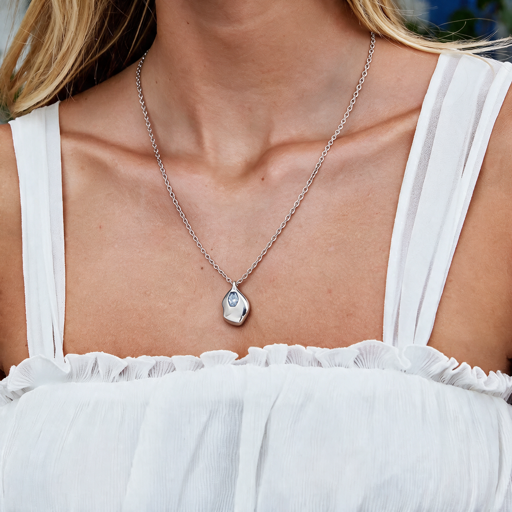 Silver necklace with blue stones worn on neck