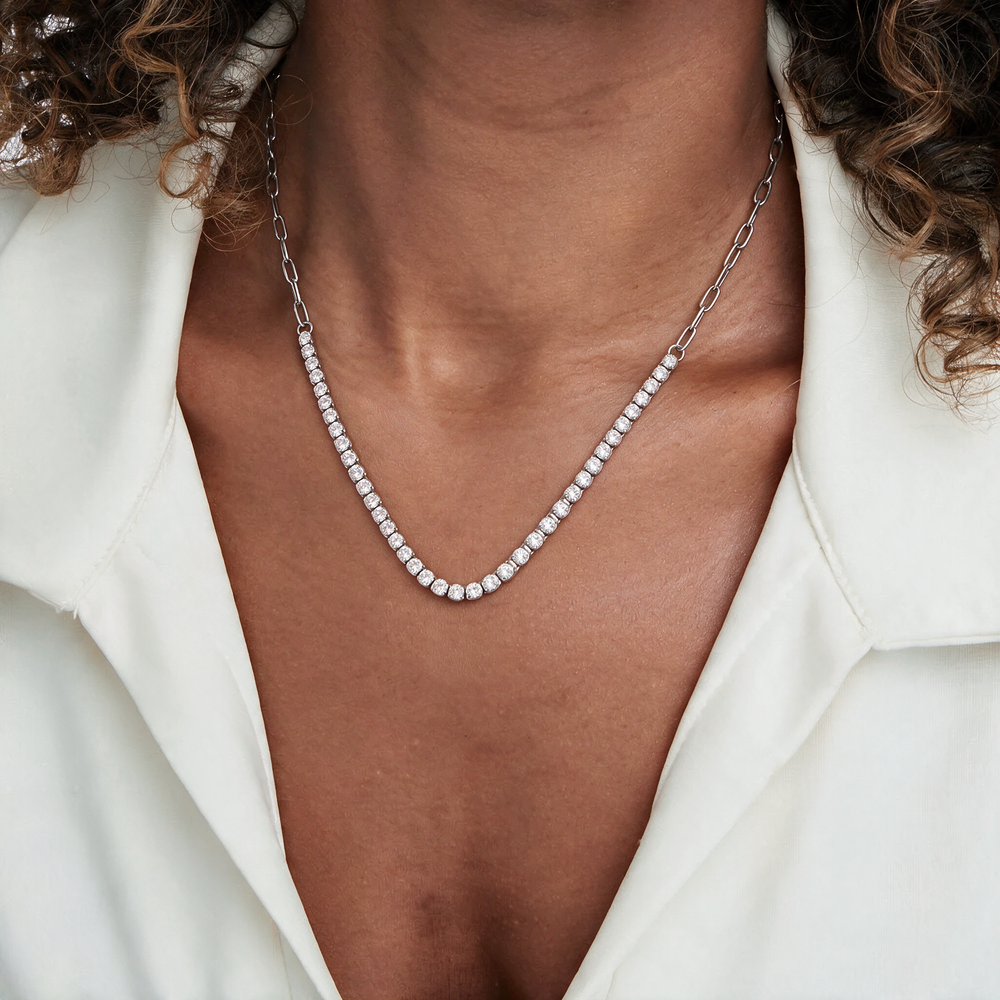 Silver necklace with white stone worn on neck