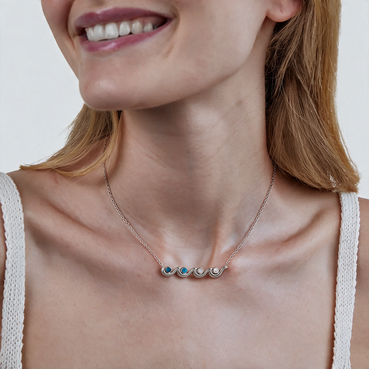 Silver necklace with blue stones worn on neck