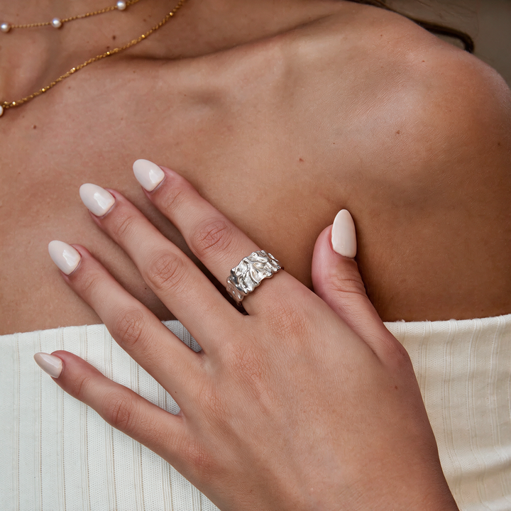 Textured silver band ring worn on hand