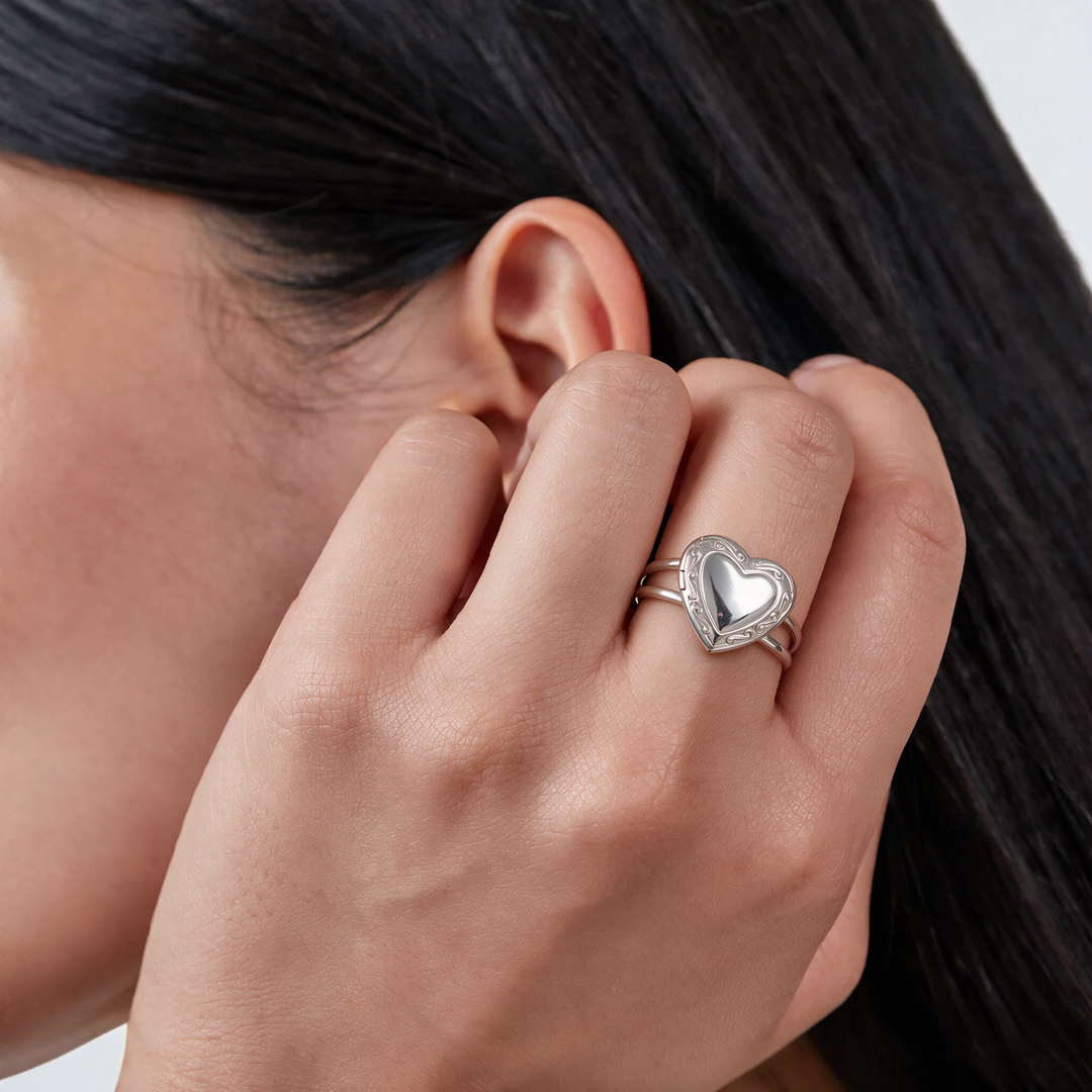 Silver heart signet ring worn on hand